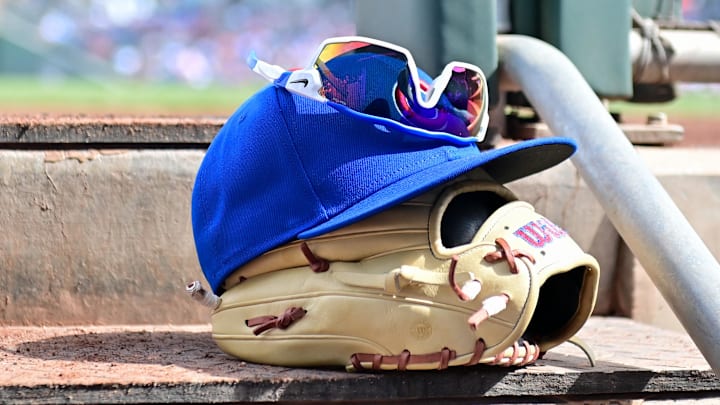 General view of a Chicago Cubs glove, hat and glasses in the first inning against the Cincinnati Reds during a spring training game at Sloan Park. General view of a Chicago Cubs glove, hat and glasses in the first inning against the Cincinnati Reds during a spring training game at Sloan Park.