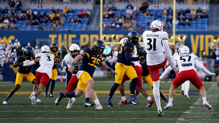 Nov 18, 2023; Morgantown, West Virginia, USA; Cincinnati Bearcats punter Mason Fletcher (31) punts the ball against the West Virginia Mountaineers in the first quarter at Milan Puskar Stadium. West Virginia won 42-21. Mandatory Credit: Kareem Elgazzar-Imagn Images Nov 18, 2023; Morgantown, West Virginia, USA; Cincinnati Bearcats punter Mason Fletcher (31) punts the ball against the West Virginia Mountaineers in the first quarter at Milan Puskar Stadium. West Virginia won 42-21. Mandatory Credit: Kareem Elgazzar-Imagn Images