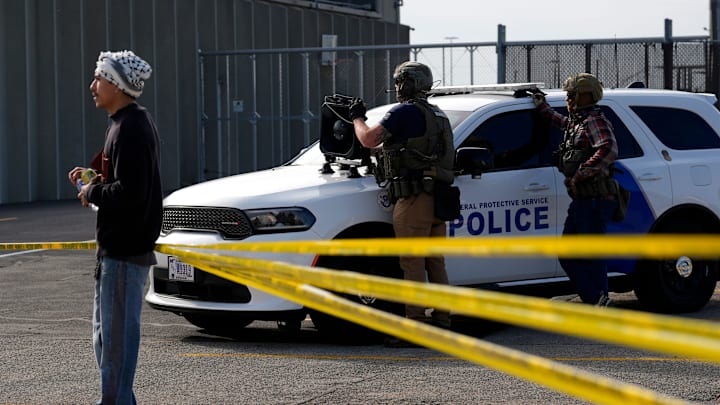 Law enforcement personnel across police tape from protesters near a rally for immigrants going to their ICE check-ins Oct. 1, 2025 at the Homeland Security Investigations office in Cedar Rapids, Iowa.