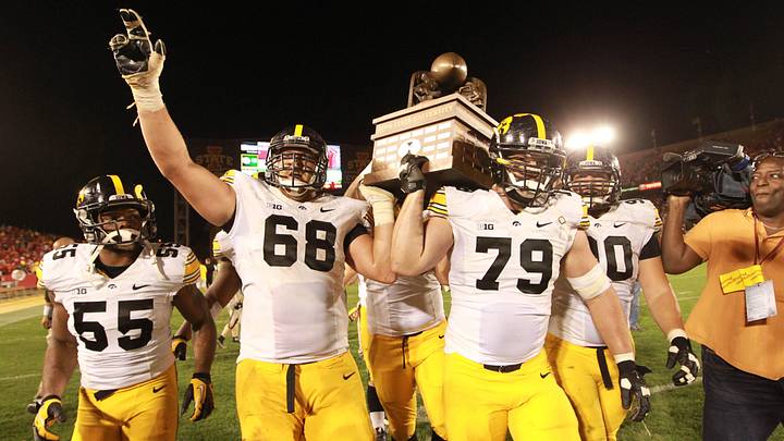September 14, 2013; Ames, IA, USA;  Iowa Hawkeyes players Marcus Collins (55), Brandon Scheriff (68) and Dominic Alvis (79) carry out the Cy-Hawk trophy after their game against the Iowa State Cyclones at Jack Trice Stadium. Iowa beat Iowa State 27-21. Mandatory Credit: Reese Strickland-USA Today Sports
