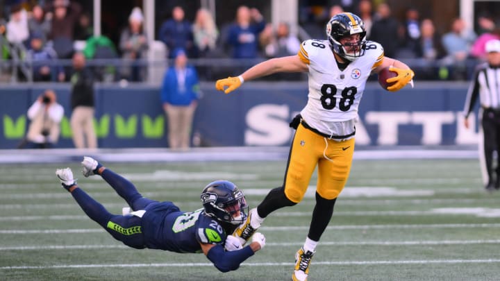 Dec 31, 2023; Seattle, Washington, USA; Pittsburgh Steelers tight end Pat Freiermuth (88) breaks a tackle attempt by Seattle Seahawks running back Zach Charbonnet (26) during the first half at Lumen Field. Mandatory Credit: Steven Bisig-USA TODAY Sports