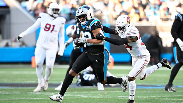 Dec 22, 2024; Charlotte, North Carolina, USA;  Carolina Panthers tight end Tommy Tremble (82) catches a pass as Arizona Cardinals safety Jalen Thompson (34) defends in the fourth quarter at Bank of America Stadium. Mandatory Credit: Bob Donnan-Imagn Images