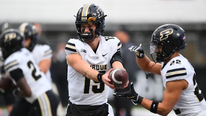 Purdue Boilermakers quarterback Ryan Browne (15) hands the ball off to running back Antonio Harris (22). Purdue Boilermakers quarterback Ryan Browne (15) hands the ball off to running back Antonio Harris (22).
