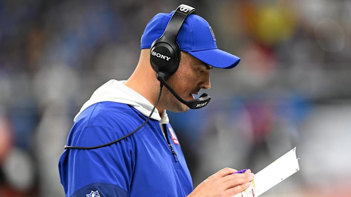 Nov 23, 2025; Detroit, Michigan, USA; New York Giants interim head coach Mike Kafka reviews the playbook during the third quarter against the Detroit Lions at  Ford Field. 