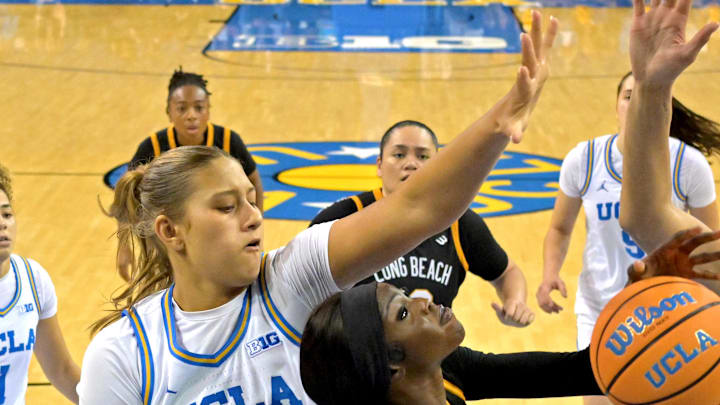 Dec 20, 2025; Los Angeles, California, USA; UCLA Bruins forward Sienna Betts (16) and center Lauren Betts (51) defend a shot by Long Beach State Beach forward Rosie Akot (2) during the second half at Pauley Pavilion presented by Wescom Financial. Mandatory Credit: Jayne Kamin-Oncea-Imagn Images