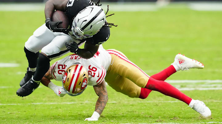 Aug 16, 2025; Paradise, Nevada, USA; Las Vegas Raiders running back Sincere McCormick (28) is tackled by San Francisco 49ers cornerback Chase Lucas (26) during the third quarter at Allegiant Stadium. Mandatory Credit: Stephen R. Sylvanie-Imagn Images