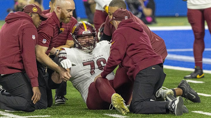 Jan 18, 2025; Detroit, Michigan, USA; Washington Commanders guard Sam Cosmi (76) received medical on the field after an injury during play against Detroit Lions during the second quarter at Ford Field. Mandatory Credit: David Reginek-Imagn Images