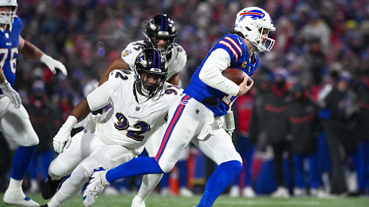 Jan 19, 2025; Orchard Park, New York, USA; Buffalo Bills quarterback Josh Allen (17) avoids a tackle by Baltimore Ravens defensive tackle Nnamdi Madubuike (92) to gain a first down in the first quarter of a 2025 AFC divisional round game at Highmark Stadium. Mandatory Credit: Mark Konezny-Imagn Images