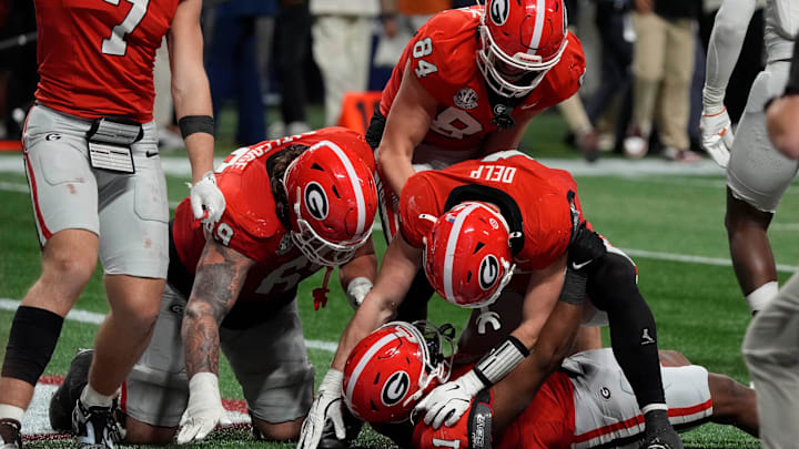 Georgia running back Trevor Etienne (1) celebrates with his teammates after scoring the game winning touchdown during overtime of the SEC championship game against Texas in Atlanta, on Saturday, Dec. 7, 2024. Georgia won 22-19.