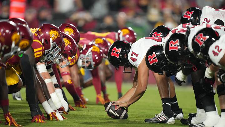 Oct 25, 2024; Los Angeles, California, USA; Helmets at the line of scrimmage as Rutgers Scarlet Knights long snapper Austin Riggs (47) snaps the ball against the Southern California Trojans in the first half at United Airlines Field at Los Angeles Memorial Coliseum. Mandatory Credit: Kirby Lee-Imagn Images
