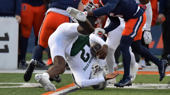 Nov 16, 2024; Champaign, Illinois, USA; Illinois Fighting Illini defensive back Torrie Cox Jr. (5) flips Michigan State Spartans quarterback Aidan Chiles (2) on this tackle during the first half at Memorial Stadium. Mandatory Credit: Ron Johnson-Imagn Images