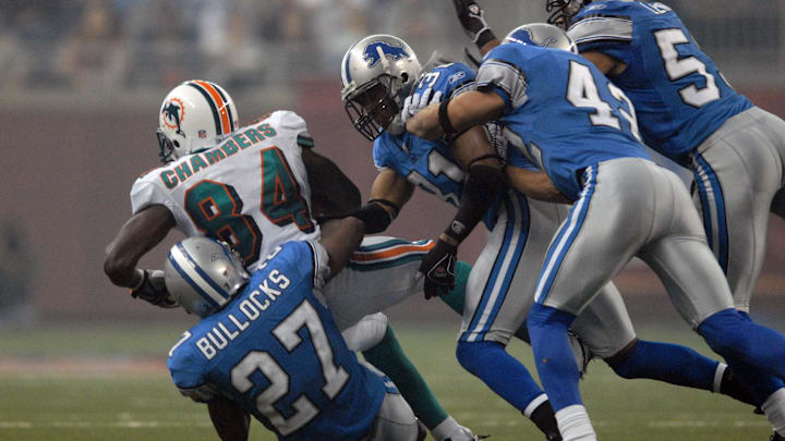 Nov. 23, 2006; Detroit, MI, USA; Miami Dolphins wide receiver (84) Chris Chambers gets tackled by Detroit Lions safety (27) Daniel Bullocks at Ford Field in Detroit, Michigan. The Dolphins defeated the Lions 27-10. Mandatory Credit: Mark J. Rebilas-Imagn Images © 2006 Mark J. Rebilas