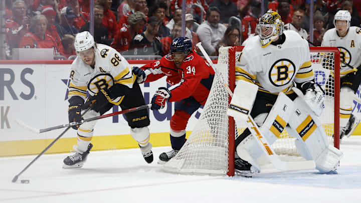 Oct 8, 2025; Washington, District of Columbia, USA; Boston Bruins right wing David Pastrnak (88) skates with the puck against behind Bruins goaltender Jeremy Swayman (1) as Washington Capitals right wing Justin Sourdif (34) chases during the first period at Capital One Arena. Mandatory Credit: Geoff Burke-Imagn Images