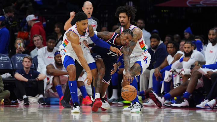Nov 24, 2024; Philadelphia, Pennsylvania, USA; Los Angeles Clippers guard Kevin Porter Jr (77) collides with Philadelphia 76ers forward KJ Martin (1) and guard Kelly Oubre Jr (9) in the fourth quarter at Wells Fargo Center. Mandatory Credit: Kyle Ross-Imagn Images