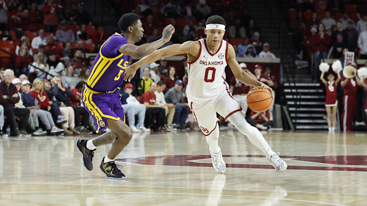 Feb 15, 2025; Norman, Oklahoma, USA;  Oklahoma Sooners guard Jeremiah Fears (0) drives to the basket as LSU Tigers guard Cam Carter (5) defends during the second half at Lloyd Noble Center. Mandatory Credit: Alonzo Adams-Imagn Images