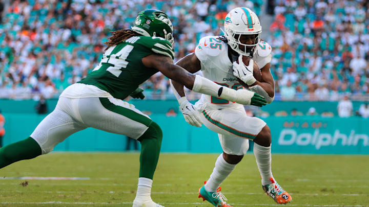 Dec 8, 2024; Miami Gardens, Florida, USA; Miami Dolphins running back Jaylen Wright (25) runs with the football against New York Jets linebacker Jamien Sherwood (44) during the second quarter at Hard Rock Stadium. Mandatory Credit: Sam Navarro-Imagn Images