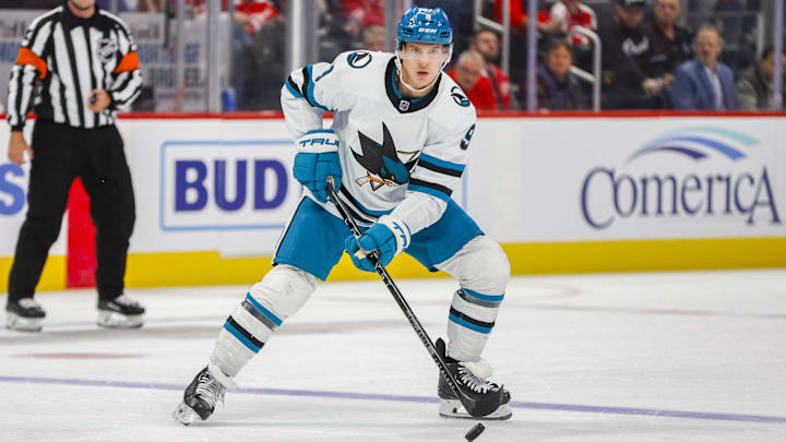 Dec 7, 2023; Detroit, Michigan, USA; San Jose Sharks defenseman Jacob MacDonald (9) handles the puck during the first period at Little Caesars Arena. Mandatory Credit: Brian Bradshaw Sevald-Imagn Images