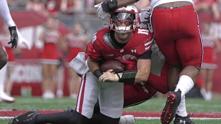 Sep 20, 2025; Madison, Wisconsin, USA; Wisconsin Badgers quarterback Danny O'Neil (18) is sacked by Maryland Terrapins linebacker Daniel Wingate (1) during the second quarter at Camp Randall Stadium. Mandatory Credit: Mark Hoffman/USA Today Network via Imagn Images