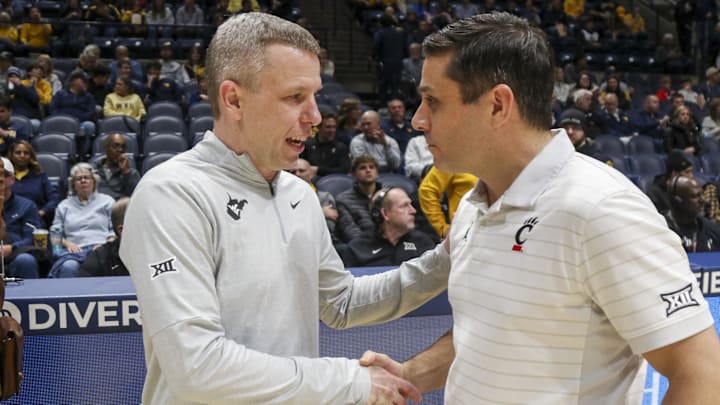 Jan 6, 2026; Morgantown, West Virginia, USA; West Virginia Mountaineers head coach Ross Hodge talks with Cincinnati Bearcats head coach Wes Miller before the game at Hope Coliseum. Mandatory Credit: Ben Queen-Imagn Images