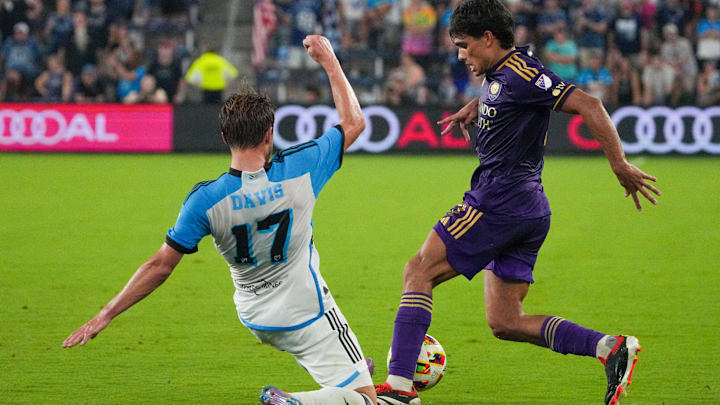 Aug 24, 2024; Kansas City, Kansas, USA; Sporting Kansas City midfielder Jake Davis (17) and Orlando City forward Ramiro Enrique (7) fight for the ball during the second half at Children's Mercy Park. Mandatory Credit: Denny Medley-USA TODAY Sports
