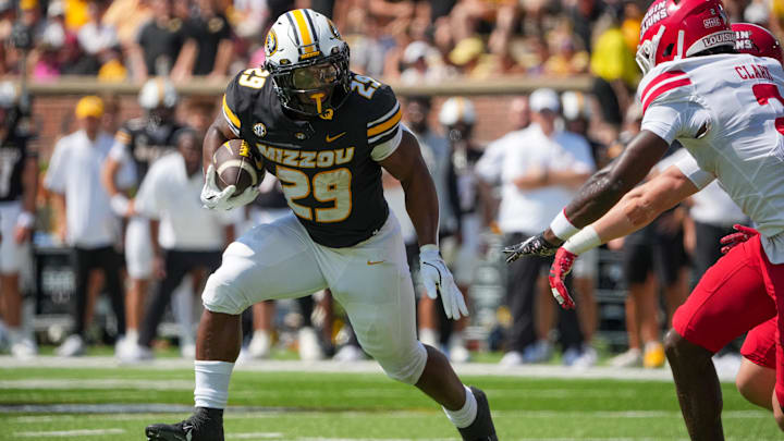 Sep 13, 2025; Columbia, Missouri, USA; Missouri Tigers running back Ahmad Hardy (29) runs the ball as Louisiana-Lafayette Ragin Cajuns safety Jalen Clark (2) defends during the first half of the game at Faurot Field at Memorial Stadium. Mandatory Credit: Denny Medley-Imagn Images