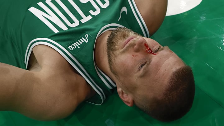 Apr 4, 2025; Boston, Massachusetts, USA; Boston Celtics center Kristaps Porzingis (8) lies on the floor after being cut by an elbow to the nose by Phoenix Suns forward Cody Martin (17) during the second half at TD Garden. Mandatory Credit: Winslow Townson-Imagn Images