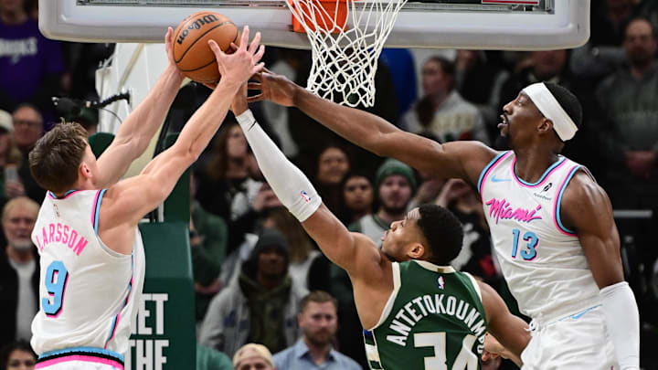 Pelle Larsson, Giannis Antetokounmpo and Bam Adebayo fight for a rebound.