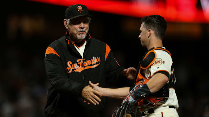 San Francisco Giants catcher Buster Posey (28) celebrates with manager Bruce Bochy (15) after defeating the Oakland Athletics at Oracle Park. 