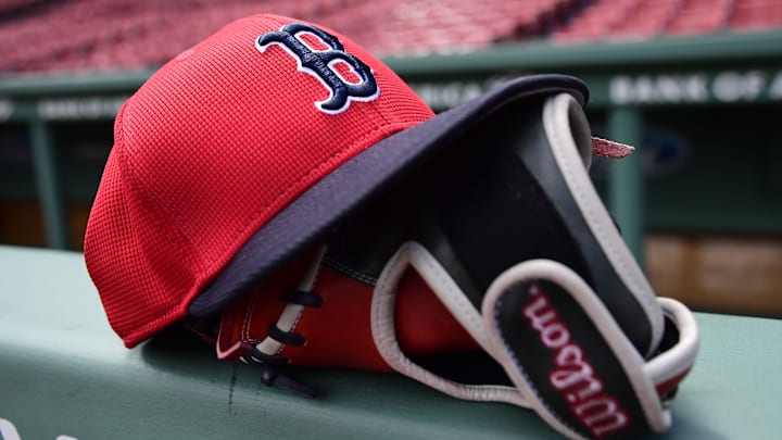 May 18, 2025; Boston, Massachusetts, USA;  A Boston Red Sox hat and glove rests on the railing by the dugout prior to a game against the Atlanta Braves at Fenway Park. Mandatory Credit: Bob DeChiara-Imagn Images