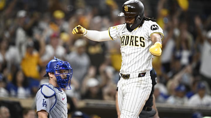 Aug 23, 2025; San Diego, California, USA; San Diego Padres right fielder Fernando Tatis Jr. (23) celebrates as he scores as Los Angeles Dodgers catcher Will Smith (16) looks on during the eighth inning at Petco Park. Mandatory Credit: Denis Poroy-Imagn Images