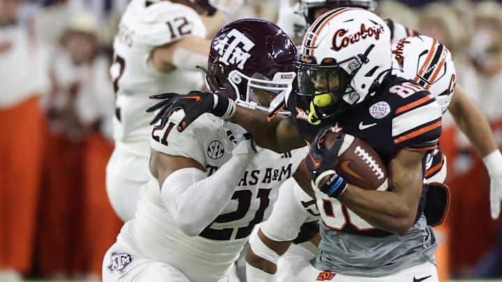Dec 27, 2023; Houston, TX, USA; Oklahoma State Cowboys wide receiver Brennan Presley (80) stiff arms Texas A&M Aggies linebacker Taurean York (21) in the second quarter at NRG Stadium. Mandatory Credit: Thomas Shea-USA TODAY Sports Dec 27, 2023; Houston, TX, USA; Oklahoma State Cowboys wide receiver Brennan Presley (80) stiff arms Texas A&M Aggies linebacker Taurean York (21) in the second quarter at NRG Stadium. Mandatory Credit: Thomas Shea-USA TODAY Sports