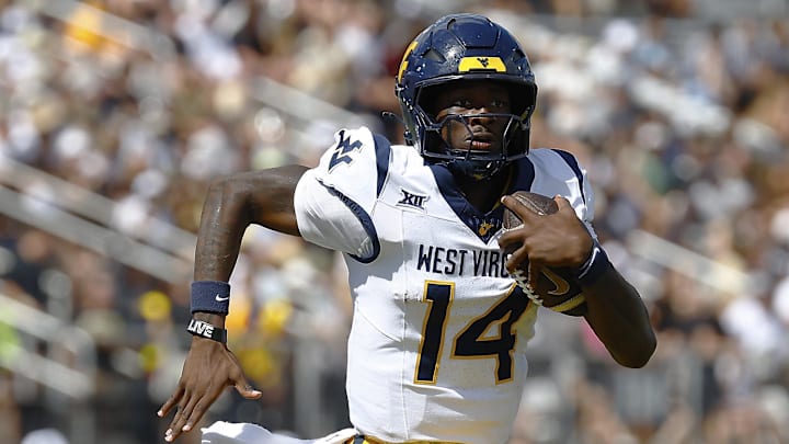 Oct 18, 2025; Orlando, Florida, USA; West Virginia Mountaineers quarterback Khalil Wilkins (14) runs the ball for a touchdown in the first half against the Central Florida Knights at Acrisure Bounce House. Mandatory Credit: Russell Lansford-Imagn Images Oct 18, 2025; Orlando, Florida, USA; West Virginia Mountaineers quarterback Khalil Wilkins (14) runs the ball for a touchdown in the first half against the Central Florida Knights at Acrisure Bounce House. Mandatory Credit: Russell Lansford-Imagn Images
