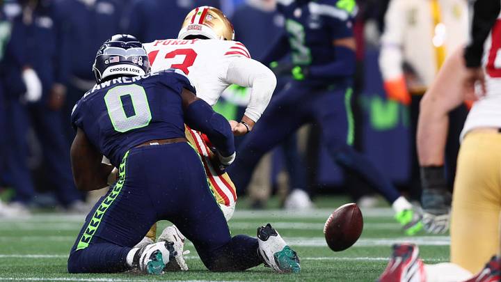 San Francisco 49ers quarterback Brock Purdy (13) is strip sacked by Seattle Seahawks defensive end DeMarcus Lawrence.
