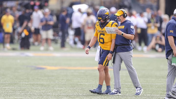 Aug 31, 2024; Morgantown, West Virginia, USA; West Virginia Mountaineers head coach Neal Brown talks with West Virginia Mountaineers quarterback Garrett Greene (6) during the second quarter against the Penn State Nittany Lions at Mountaineer Field at Milan Puskar Stadium. 