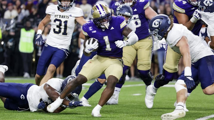 Sep 6, 2025; Seattle, Washington, USA; Washington Huskies running back Jonah Coleman (1) breaks a tackle attempt by UC Davis Aggies defensive lineman Derrell Porter (35) to rush for a touchdown during the second quarter at Husky Stadium. Mandatory Credit: Joe Nicholson-Imagn Images