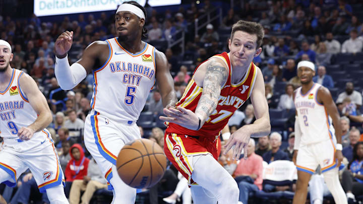 Oct 17, 2024; Oklahoma City, Oklahoma, USA; Atlanta Hawks guard Vit Krejci (27) passes the ball around Oklahoma City Thunder guard Luguentz Dort (5) during the second quarter at Paycom Center. Mandatory Credit: Alonzo Adams-Imagn Images