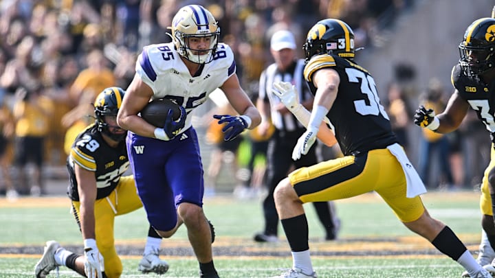 Huskies tight end Keleki Latu (85) heads upfield as Iowa defensive back Quinn Schulte (30) tries to make the tackle.