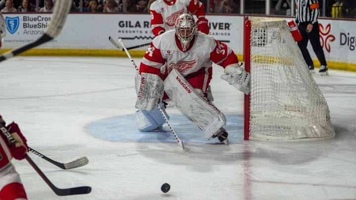 Detroit Red Wings goalie Alex Lyon (34) reacts to the puck as it bounces toward the net off the stick of an opposing player.