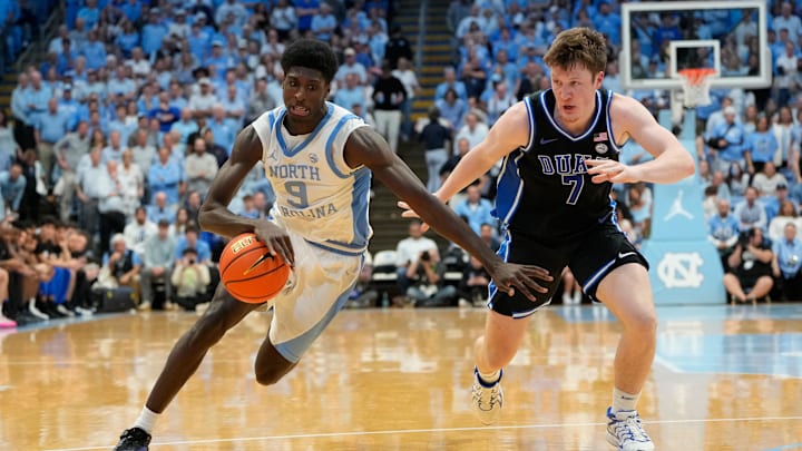 Mar 8, 2025; Chapel Hill, North Carolina, USA;  North Carolina Tar Heels guard Drake Powell (9) dribbles as Duke Blue Devils guard Kon Knueppel (7) defends in the second half at Dean E. Smith Center. Mandatory Credit: Bob Donnan-Imagn Images