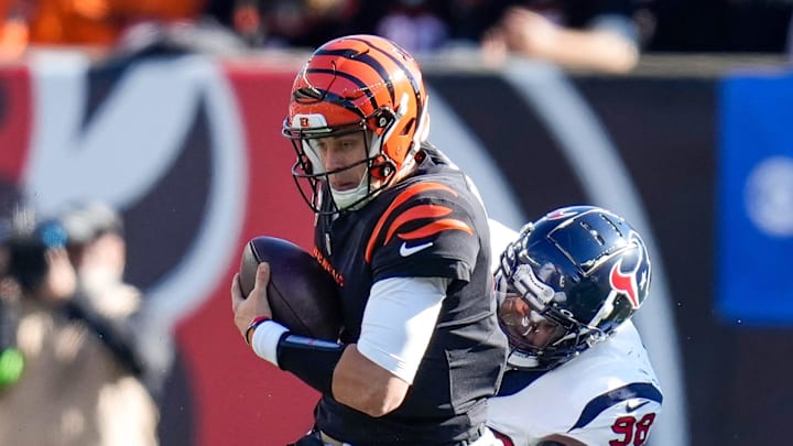 Cincinnati Bengals quarterback Joe Burrow (9) fights off tackles before being brought down on third