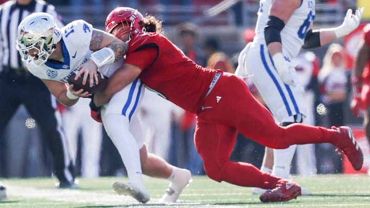 Louisville Cardinals defensive lineman Ashton Gillotte (9) brings down Kentucky Wildcats quarterback Devin Leary (13) for a sack in the first half Saturday. Nov. 25, 2023. Louisville Cardinals defensive lineman Ashton Gillotte (9) brings down Kentucky Wildcats quarterback Devin Leary (13) for a sack in the first half Saturday. Nov. 25, 2023.