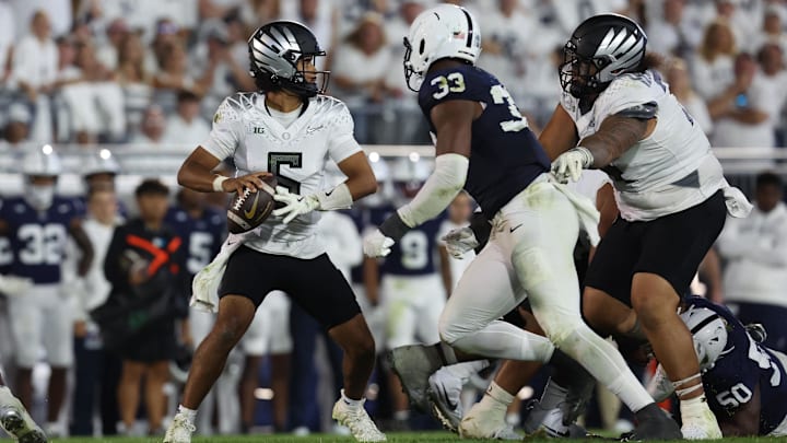 Sep 27, 2025; University Park, Pennsylvania, USA; Oregon Ducks quarterback Dante Moore (5) throws during the second quarter against the Penn State Nittany Lions  at Beaver Stadium. Mandatory Credit: Matthew O'Haren-Imagn Images