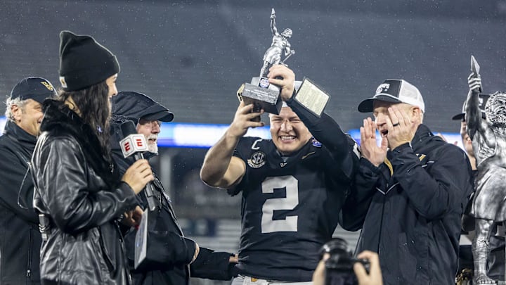Dec 27, 2024; Birmingham, AL, USA;  Vanderbilt Commodores quarterback Diego Pavia (2) hoists the MVP trophy after defeating the Georgia Tech Yellow Jackets in the 2024 Birmingham Bowl at Protective Stadium. Mandatory Credit: Vasha Hunt-Imagn Images