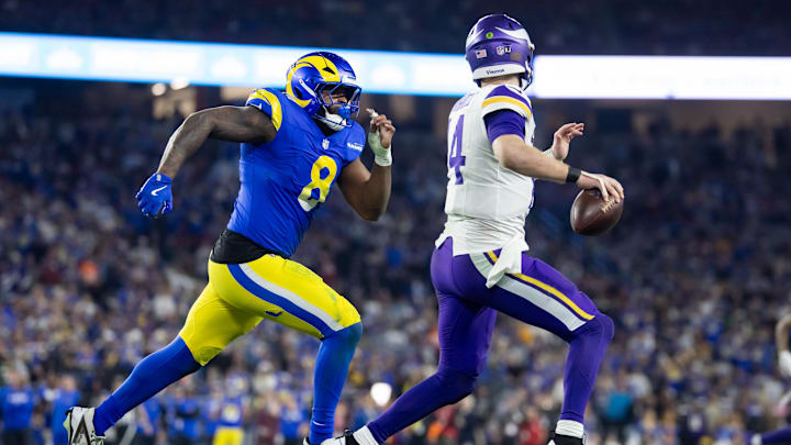Jan 13, 2025; Glendale, AZ, USA; Minnesota Vikings quarterback Sam Darnold (14) is pursued by Los Angeles Rams linebacker Jared Verse (8) during an NFC wild card game at State Farm Stadium. Mandatory Credit: Mark J. Rebilas-Imagn Images