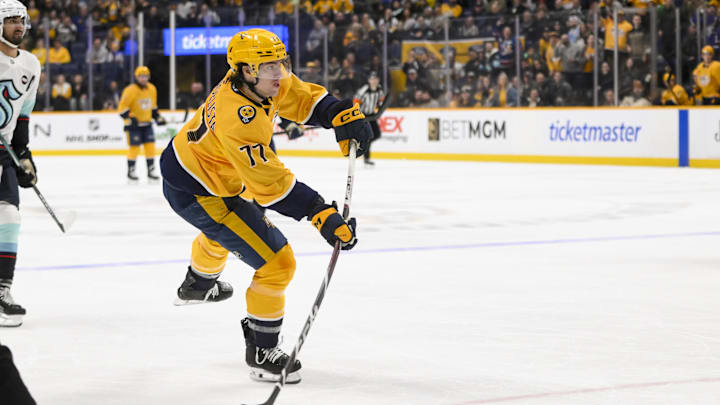 Mar 6, 2025; Nashville, Tennessee, USA;  Nashville Predators right wing Luke Evangelista (77) scores on an empty net shot against the Seattle Kraken during the third period at Bridgestone Arena. Mandatory Credit: Steve Roberts-Imagn Images