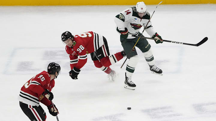 Nov 26, 2025; Chicago, Illinois, USA; Minnesota Wild center Joel Eriksson Ek (14) checks Chicago Blackhawks center Connor Bedard (98)