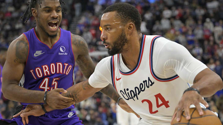 Nov 9, 2024; Inglewood, California, USA; Los Angeles Clippers guard Norman Powell (24) is defended by Toronto Raptors guard Davion Mitchell (45) in the second half at Intuit Dome. Mandatory Credit: Jayne Kamin-Oncea-Imagn Images