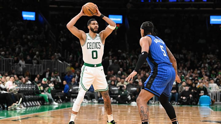 Boston Celtics forward Jayson Tatum (0) looks to pass the ball over Orlando Magic forward Paolo Banchero (5) during the second half at TD Garden.