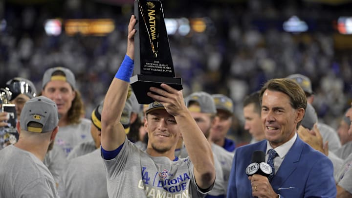 Oct 20, 2024; Los Angeles, California, USA; Los Angeles Dodgers shortstop Tommy Edman (25) receives the MVP trophy on the podium after defeating the New York Mets in Game 6 of the NLCS for the 2024 MLB playoffs to advance to the World Series at Dodger Stadium.