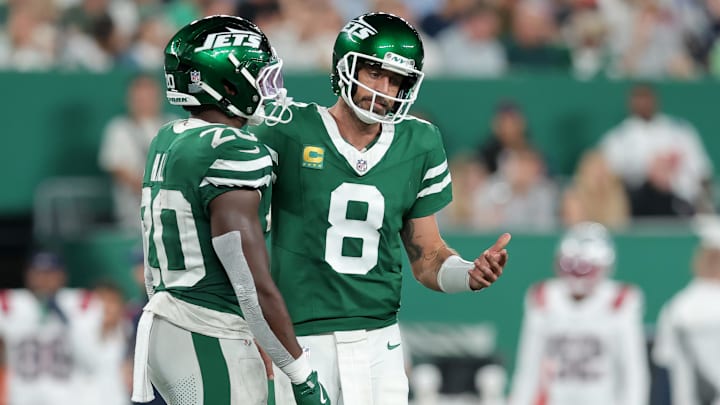 Sep 19, 2024; East Rutherford, New Jersey, USA; New York Jets quarterback Aaron Rodgers (8) reacts as he talks to running back Breece Hall (20) during the third quarter against the New England Patriots at MetLife Stadium.